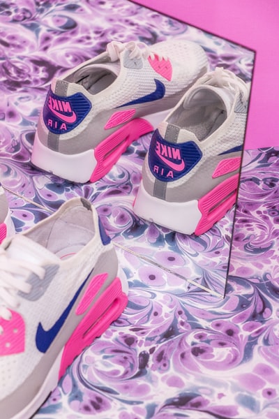 一双白灰色和粉色的Nike Air Max运动鞋在镜子前的特写照片